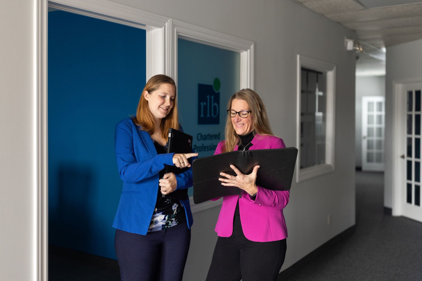 Two people reviewing a file together at RLB Shelburne office.